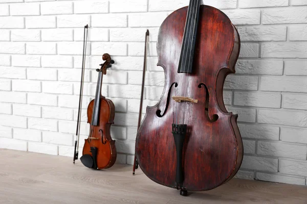 Violoncelo e violino no fundo da parede — Fotografia de Stock