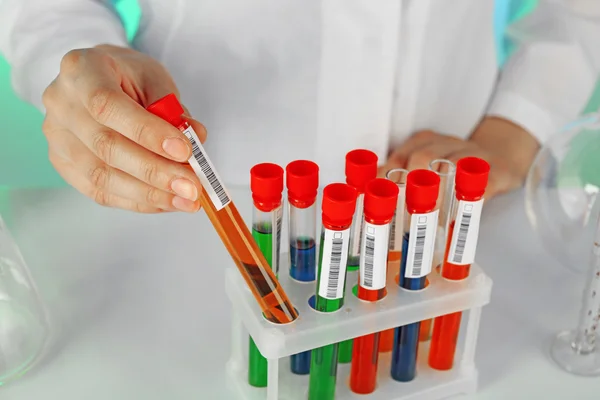 Test tubes with liquid in scientist hand — Stock Photo, Image