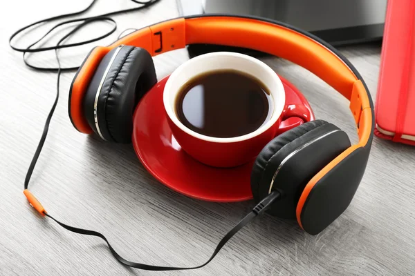 Headphones with tablet and cup of coffee on wooden table close up — Stock Photo, Image
