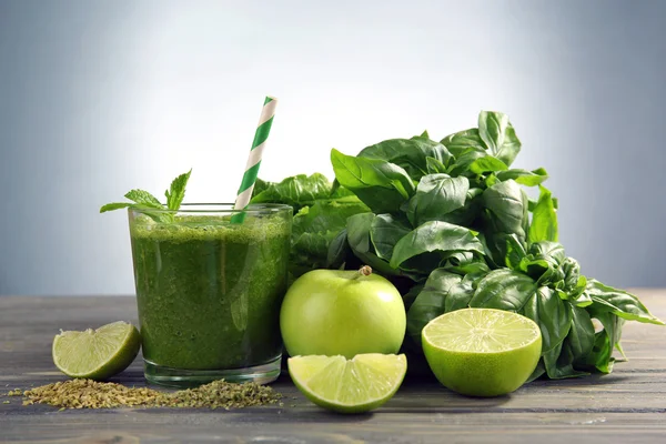 Groene gezond vruchtensap met groenten en kruiden op grijze achtergrond — Stockfoto