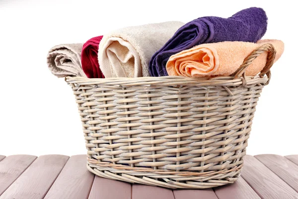 Kleurrijke handdoeken in mand geïsoleerd op wit — Stockfoto