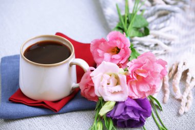 Kahve odasındaki kanepede kitap yakınındaki çiçekli