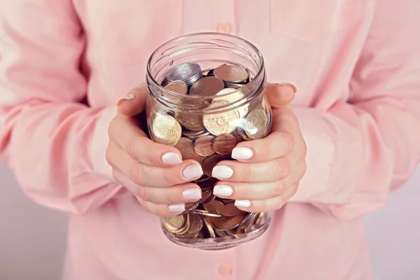 Жінка тримає грошову банку з монетами крупним планом — стокове фото