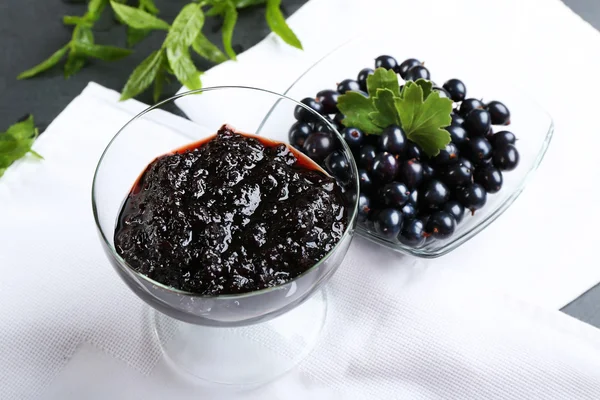 Tasty currant jam with berries on table close up — Stock Photo, Image