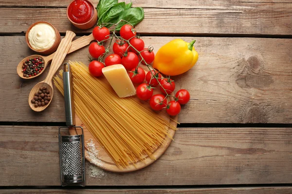 Makarna spagetti domates, peynir ve fesleğen rustik ahşap zemin üzerine — Stok fotoğraf