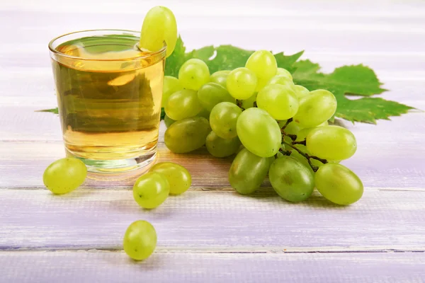 Copo de suco de uva na mesa de madeira, close-up — Fotografia de Stock