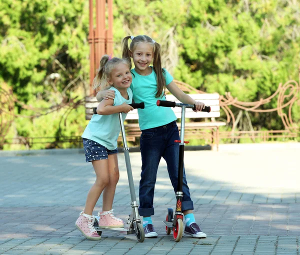 Küçük kızlar scooter üzerinde sürme — Stok fotoğraf