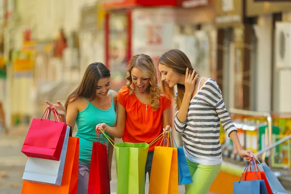 Vackra unga kvinnor med shoppingväskor på stadens gata — Stockfoto