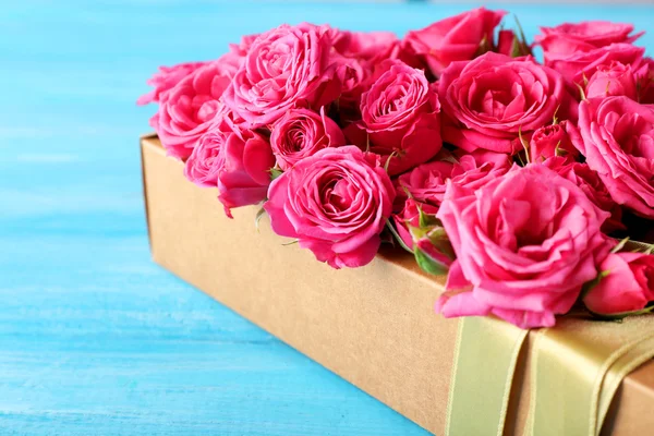 Красивые розы в коробке на деревянном фоне — стоковое фото
