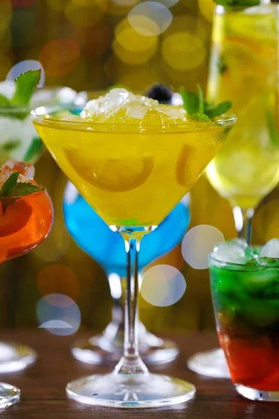 Glasses of cocktails with ice on blurred lights background — Stock Photo, Image