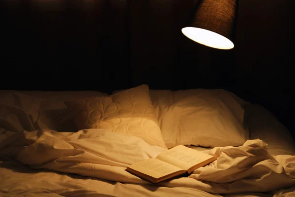 Buch im Bett aufschlagen — Stockfoto