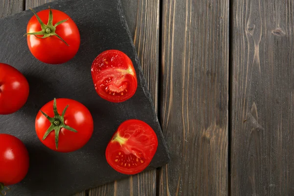 Rote Tomaten auf hölzernem Hintergrund — Stockfoto