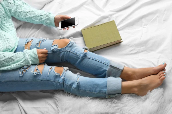 Woman in blue jeans watching phone