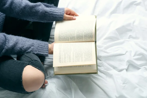 Vrouw in zwarte jeans lezen van boek — Stockfoto