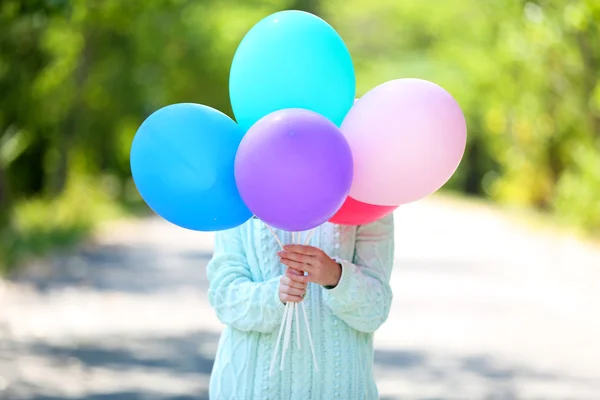 Girl holding balloons near face — Stock Photo, Image