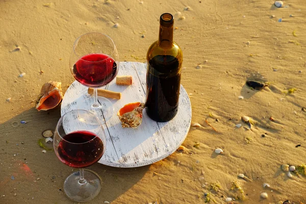 Botella de vino y copas sobre arena — Foto de Stock