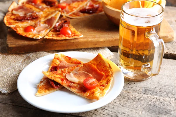 Sliced pizza served with beer — Stock Photo, Image