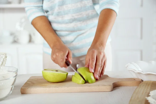 Женские руки нарезают яблоко для пирога — стоковое фото