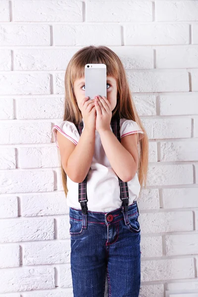 Güzel küçük bir kız ile hareket eden telefon — Stok fotoğraf