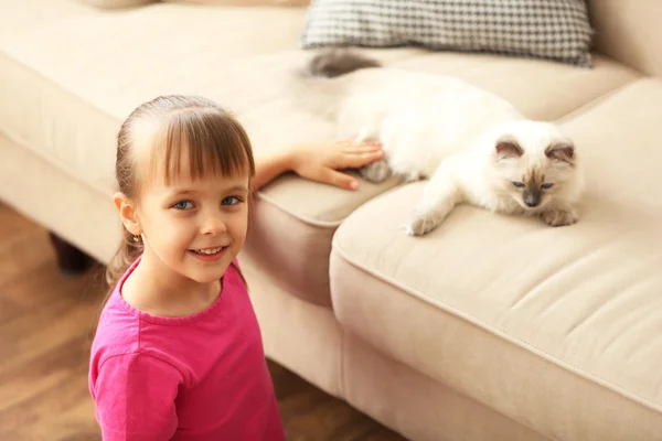 Meisje spelen met kitten thuis — Stockfoto