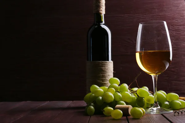 Láhve a sklenice vína s hroznovým vínem — Stock fotografie