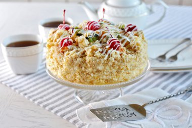 Tereyağı kek kiraz stand ve ışık arka plan üzerinde tablo ayarı ile