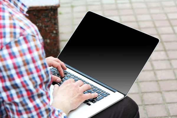 Jongeman met laptop buiten — Stockfoto