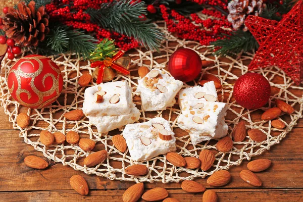 Turrón dulce con almendras y mesa de decoración de Navidad de cerca —  Fotos de Stock