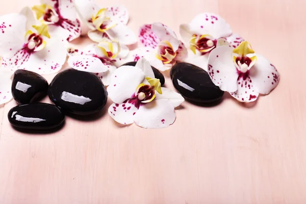 Orchid en zen stenen op houten achtergrond close-up — Stockfoto