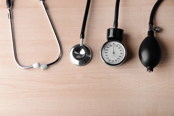 Blutdruckmessgerät und Stethoskop, auf Holzgrund — Stockfoto