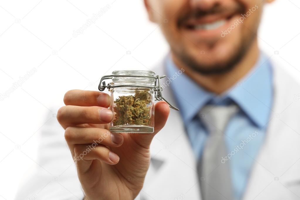 Doctor hand holding bottle with medical cannabis close up
