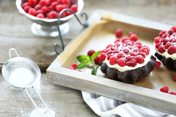 Sweet cakes with raspberries on wooden table background — Stock Photo, Image