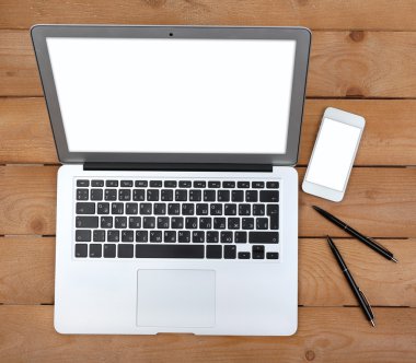 Kalem ve akıllı telefon açık defter üzerinde ahşap arka plan, üstten görünüm