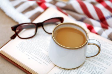 Oturma odasında kanepede kitap ile kahve