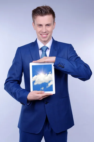 Biznesmen trzymając tablet Pc z nieba w ekran. Cloud computing koncepcja — Zdjęcie stockowe