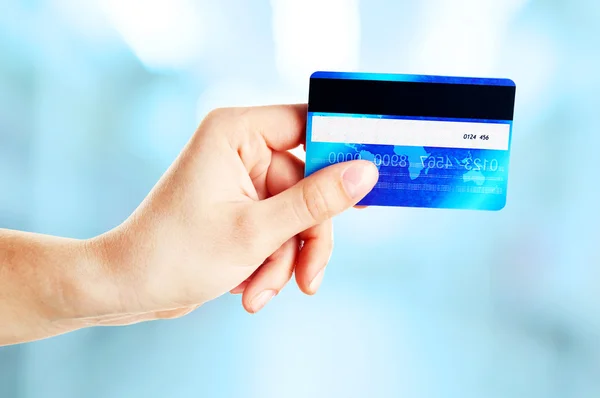 Hand som håller kreditkort på abstrakt bakgrund — Stockfoto
