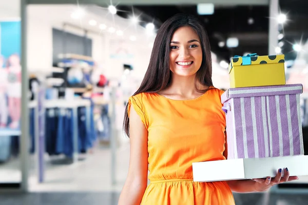 Schöne junge Frau mit Einkaufskartons im Einkaufszentrum — Stockfoto