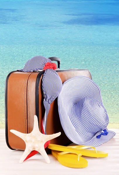 スーツケースとビーチの背景に旅行用アクセサリー — ストック写真