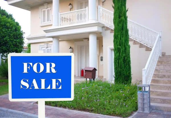 Real estate sign in front of new house for sale — Stock Photo, Image