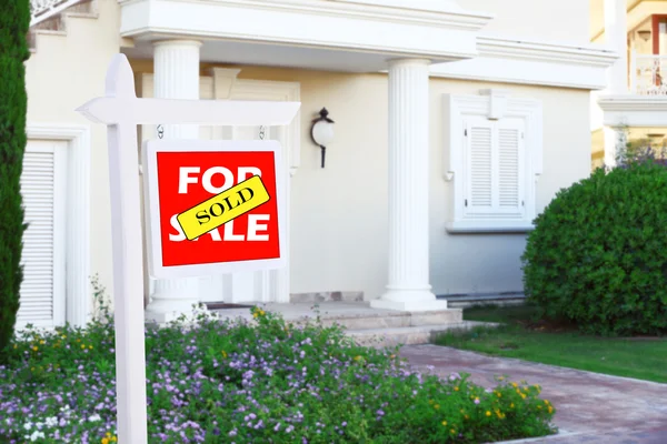 Immobilienschild vor neuem Haus zum Verkauf — Stockfoto