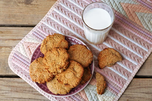 Hausgemachte Kekse und ein Glas Milch auf dem Tisch aus nächster Nähe — Stockfoto