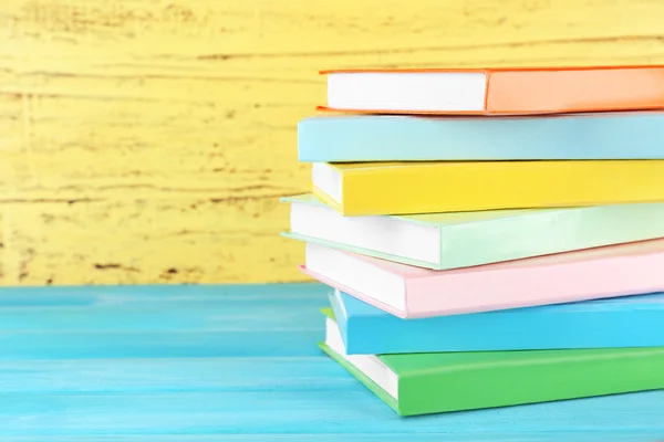 Livros coloridos sobre fundo amarelo — Fotografia de Stock