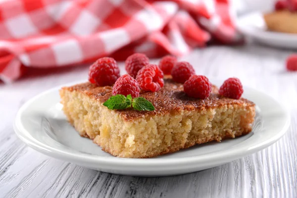 Fresh pie with raspberry in white plate on wooden table, closeup — Stock Photo, Image