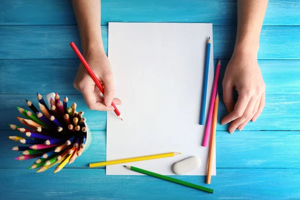 Hand met kleur potloden en blanco vel papier — Stockfoto