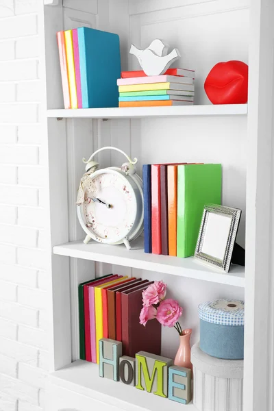 Books and decor on shelves — Stock Photo, Image