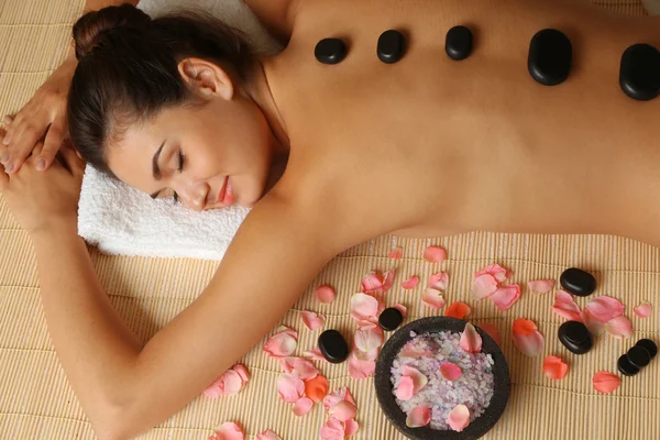 Young woman with pebbles on her back — Stock Photo, Image