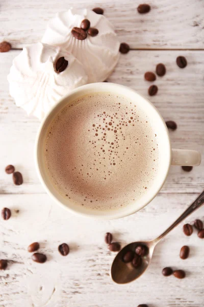 Cup of coffee with beans and zephyr on wooden table, top view — Stock Photo, Image