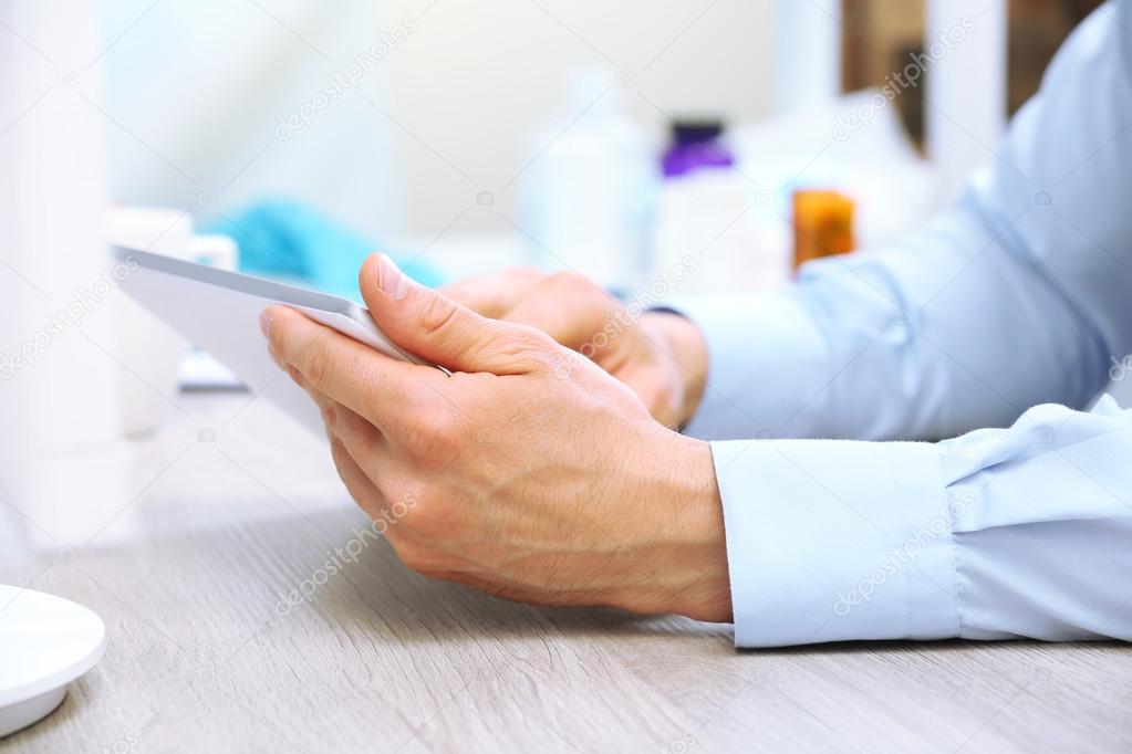 Doctor working at table in office