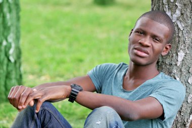 Parkta oturan yakışıklı Afrikalı-Amerikalı adam