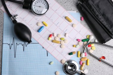 Tansiyon ölçer, hap ve gri arka plan üzerinde stetoskop